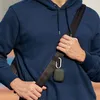 A person wearing a navy blue hoodie is carrying a bag with an AirPods case attached to the strap. Podgląd zdjęcia produktu