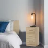 A bedroom scene with a bed and a nightstand. Produktbild-Vorschau