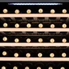 A close-up view of several shelves of a wine cooler filled with wine bottles. Produktbild-Vorschau