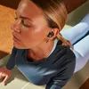 A woman is doing yoga while wearing earbuds. Produktbild-Vorschau