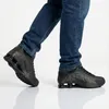 A person wearing black Nike Shox R4 sneakers and blue jeans, shown from the knees down. Produktbild-Vorschau