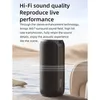 A black portable speaker is shown in a serene outdoor setting with water and sand dunes in the background. Produktbild-Vorschau