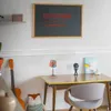 A desk setup with a guitar, a lamp, and a framed picture on the wall. Anteprima dell’immagine prodotto