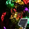 Close-up of solar-powered butterfly-shaped string lights with a solar panel in the foreground. Produktbild-Vorschau