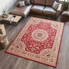 A red oriental rug is placed on a dark wooden floor in a living room setting with a brown leather sectional sofa and a wooden coffee table.