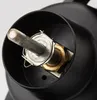 A close-up view of a fishing reel's internal mechanism, showing a metal shaft, a brass nut, and a black housing. Produktbild-Vorschau