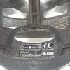 The inside of a helmet with labels and straps. Produktbild-Vorschau