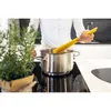 A person is adding spaghetti to a pot of boiling water on a stovetop. Voir les images du produit
