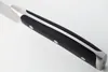 A close-up view of the handle and part of the blade of a chef's knife. Voir les images du produit