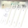 A set of LED light strips and accessories laid out on a white background, with a blurred kitchen scene in the background. Produktbild-Vorschau