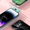 A teal mini-power bank is charging two iPhones, one is in the foreground and the other is in the background. Produktbild-Vorschau