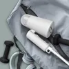 A travel garment steamer and accessories are laid out on a gray fabric surface. Produktbild-Vorschau