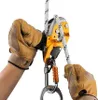 Hands wearing gloves are shown operating a descender device attached to a rope. Produktbild-Vorschau