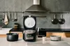 A modern kitchen counter with a rice cooker and its accessories. Produktbild-Vorschau