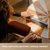 A person is using a hair styling tool on a table. Produktbild-Vorschau