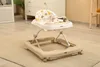 A baby walker is placed on a rug in a room with a dresser and a plant in the background. Produktbild-Vorschau