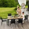 A couple is enjoying a meal at a table on a wooden deck, surrounded by a lush green garden. Produktbild-Vorschau