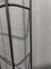 A close-up view of a metal wire mesh structure, likely part of a cable management system or similar product, against a lightly textured white background. Anteprima dell’immagine prodotto