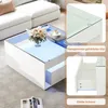 A white coffee table with glass top and LED lighting, shown in a living room setting with a sofa and a vase of flowers. Close-up insets highlight the glass and drawer mechanism. Voir les images du produit