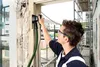 A person is using a sander to renovate a window frame. Produktbild-Vorschau