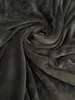 A close-up, swirled view of a dark gray, soft fabric, likely a blanket or bedsheet. Produktbild-Vorschau