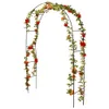 A black metal garden arch decorated with artificial green vines and red and orange roses. Podgląd zdjęcia produktu