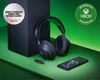 A black Xbox console, headphones, and smartphone are arranged on a green surface, with a green background. Produktbild-Vorschau