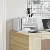 A white desk organizer with compartments, holding files, a clock, and pens, placed on a wooden desk. Náhľad obrázku produktu