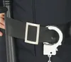 Close-up of a black belt with a silver buckle and handcuffs attached. Anteprima dell’immagine prodotto
