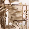 A close-up view of a wooden marble run construction kit with marbles on the tracks. Voir les images du produit