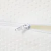 Close-up of a white mattress cover with a zipper partially open, revealing a light yellow foam interior. Produktbild-Vorschau