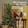 A woman and a child are decorating a Christmas tree in a cozy living room setting. Produktbild-Vorschau