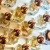 A collection of small perfume bottles with gold caps and red jewels. Náhled obrázku produktu