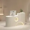 A modern reception desk with a computer and a small plant. Produktbild-Vorschau