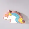 A close-up, angled shot of a pink unicorn-shaped ceiling light mounted on a white ceiling. Produktbild-Vorschau