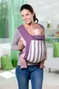 A woman is holding a baby in a purple baby carrier. Produktbild-Vorschau