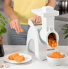 A person is using a white electric grater to grate carrots in a kitchen setting. Produktbild-Vorschau