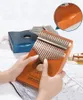 Hands holding a wooden kalimba instrument, with another kalimba in the background. Produktbild-Vorschau