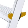 A close-up view of a section of an aluminum stepladder, focusing on the yellow anti-slip feet and the connection point between the step and the ladder's side rail. Anteprima dell’immagine prodotto