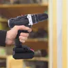 A hand holding a cordless drill, preparing to drill into a wall. Produktbild-Vorschau