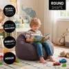 A young boy is reading a book while sitting on a beanbag chair in a child's room. The room has toys and decorations like animal wall decals. Voir les images du produit