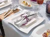 A table setting with plates, cutlery, and a glass of wine. Produktbild-Vorschau