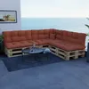 A sectional outdoor sofa made of wooden pallets with orange cushions, placed on a balcony overlooking the sea. Voir les images du produit