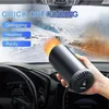 A hand holding a black portable car heater/defogger inside a car, with the windshield in the background showing a snowy landscape. Anteprima dell’immagine prodotto