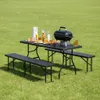 A picnic table set with food and a grill on a grassy lawn. Produktbild-Vorschau