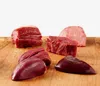 Several cuts of raw meat are arranged on a wooden surface against a white background. Produktbild-Vorschau