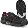 A black safety shoe with red accents and a white sole is shown against a white background. Another shoe is visible in the background, showing its sole. Produktbild-Vorschau