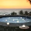 Floating lights in a hot tub at sunset by the ocean. Produktbild-Vorschau