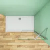 A top-down view of a shower tray with a glass shower wall and support arm, set against a light green wall and wooden floor. Produktbild-Vorschau