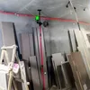 A laser level mounted on a telescopic pole in a room with construction materials. Produktbild-Vorschau